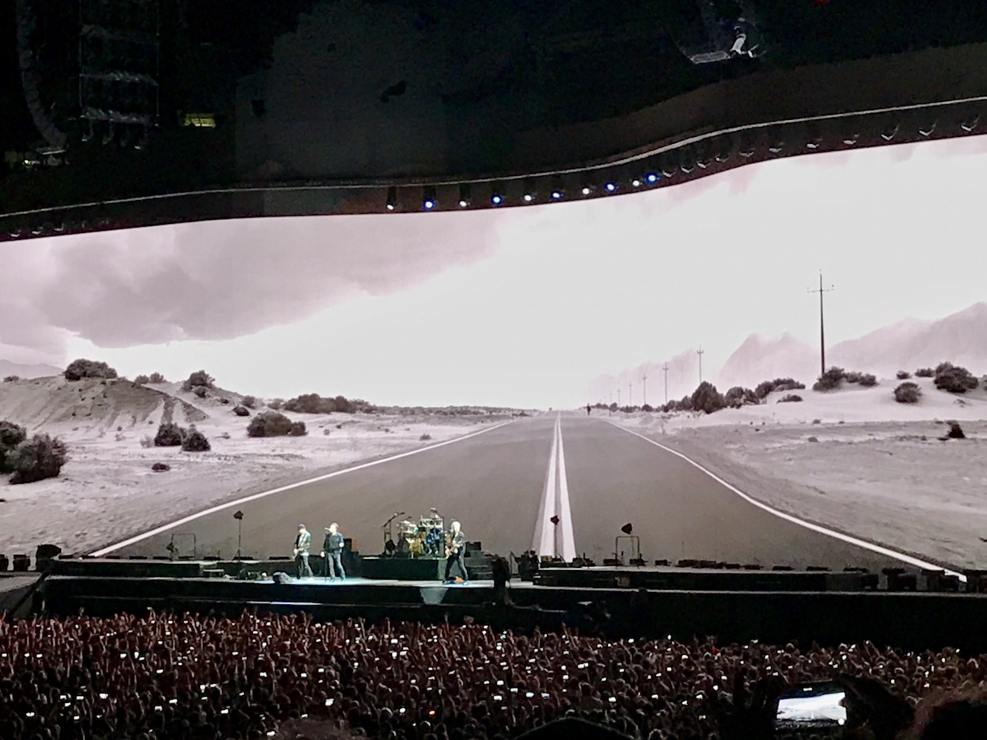 U2 in Cleveland with a picture of a road behind them