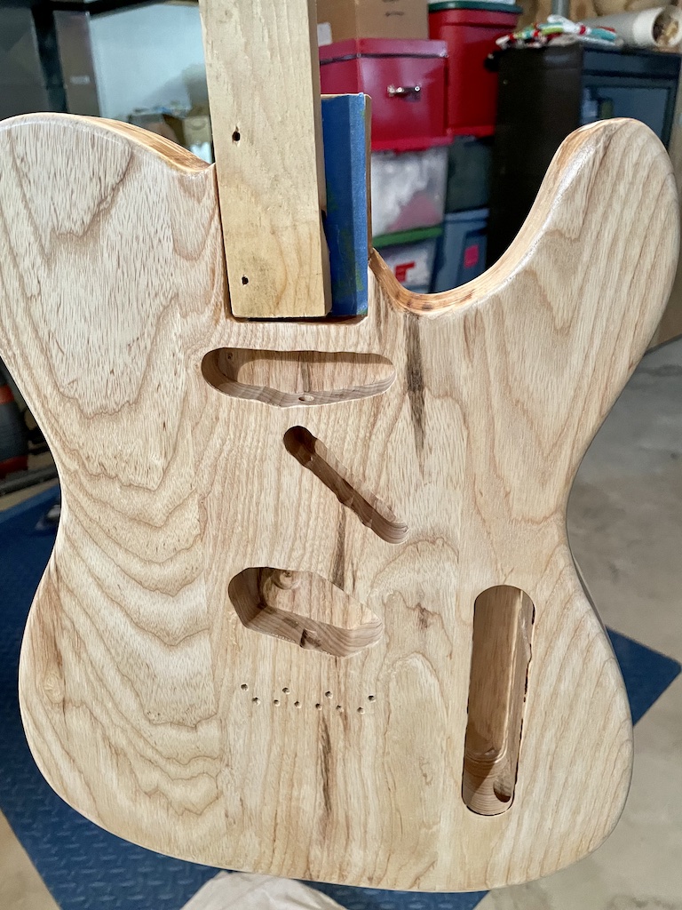 guitar body attached to scrap wood paint stick