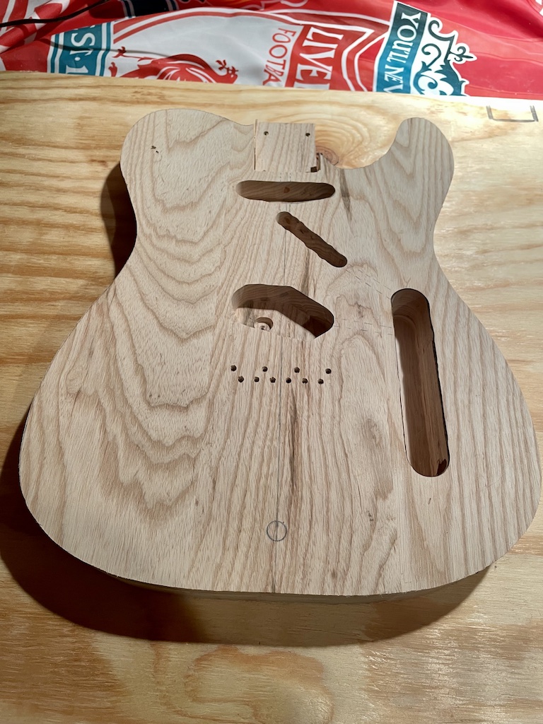 front of guitar body after routing and being cut out from wood